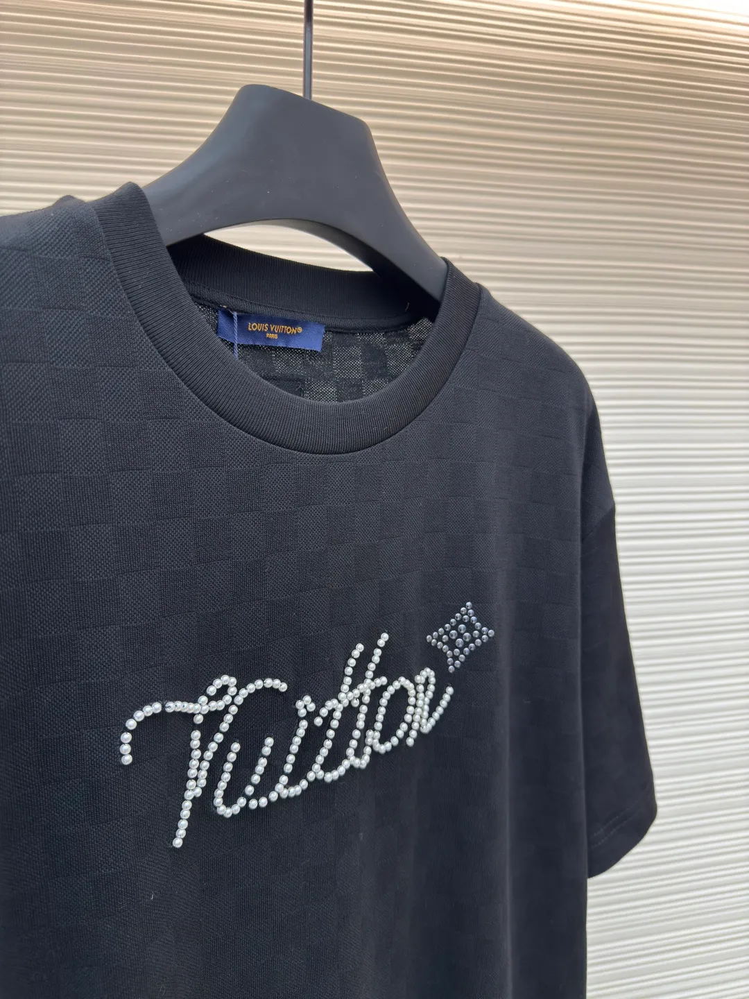 LOUIS VUITTON Hand-signed pearl round neck checkerboard short sleeves ●Authentic product: Purchased and developed by 9574 ●Item No.: 1680354-A55 ●Fabric: Silk full jacquard fabric ●Technology: Beaded embroidery production ●Version: Fitted version ●Weight: about 270 grams ●Size: XS-S-M-L ●Description: Made of 50S double-stranded optical filament, 210g; with 32S double-yarn thread, 300g. The smooth jacquard fabric uses silk threads with better gloss as warp and weft threads, and uses complex jacquard technology to weave delicate and exquisite triangular patterns on the entire fabric. The fabric not only has a beautiful appearance and feel, but also has an overall higher quality feel. The silk jacquard fabric design adds a unique charm to the product through exquisite patterns and textures. The chest presents beaded embroidery and rivet technology combined with patterns. Beaded embroidery is a special decorative method that combines beads and embroidery technology. This decorative method usually uses pearl materials on textiles, which are stitched and embroidered to form various patterns and shapes. Bead embroidery has unique artistic characteristics and expressive power to create colorful, clear-layered and three-dimensional decorative effects. The overall wiring is straight and delicate, the fabric is comfortable and soft, and the color is consistent without color difference. It can be matched with the same style to create a fashionable look and control various occasions. Customized accessories, complete with three standards, same style for men and women!